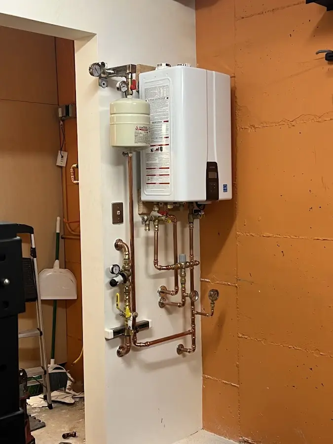 Plumbing technician inspecting water heater connections in Colton